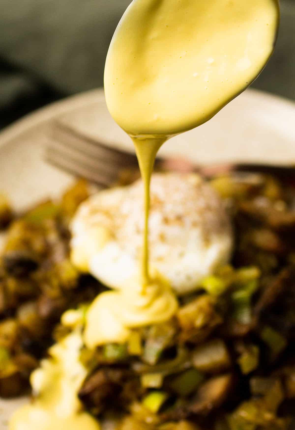 Drizzling hollandaise over hash.