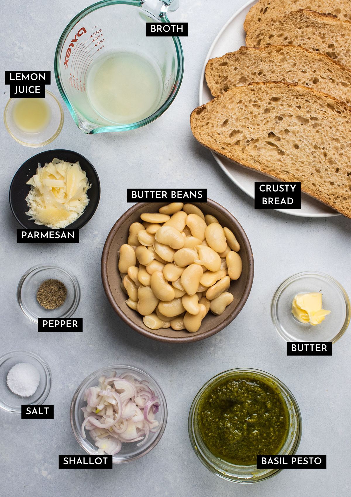 Recipe ingredients, organized into individual bowls on a white table.
