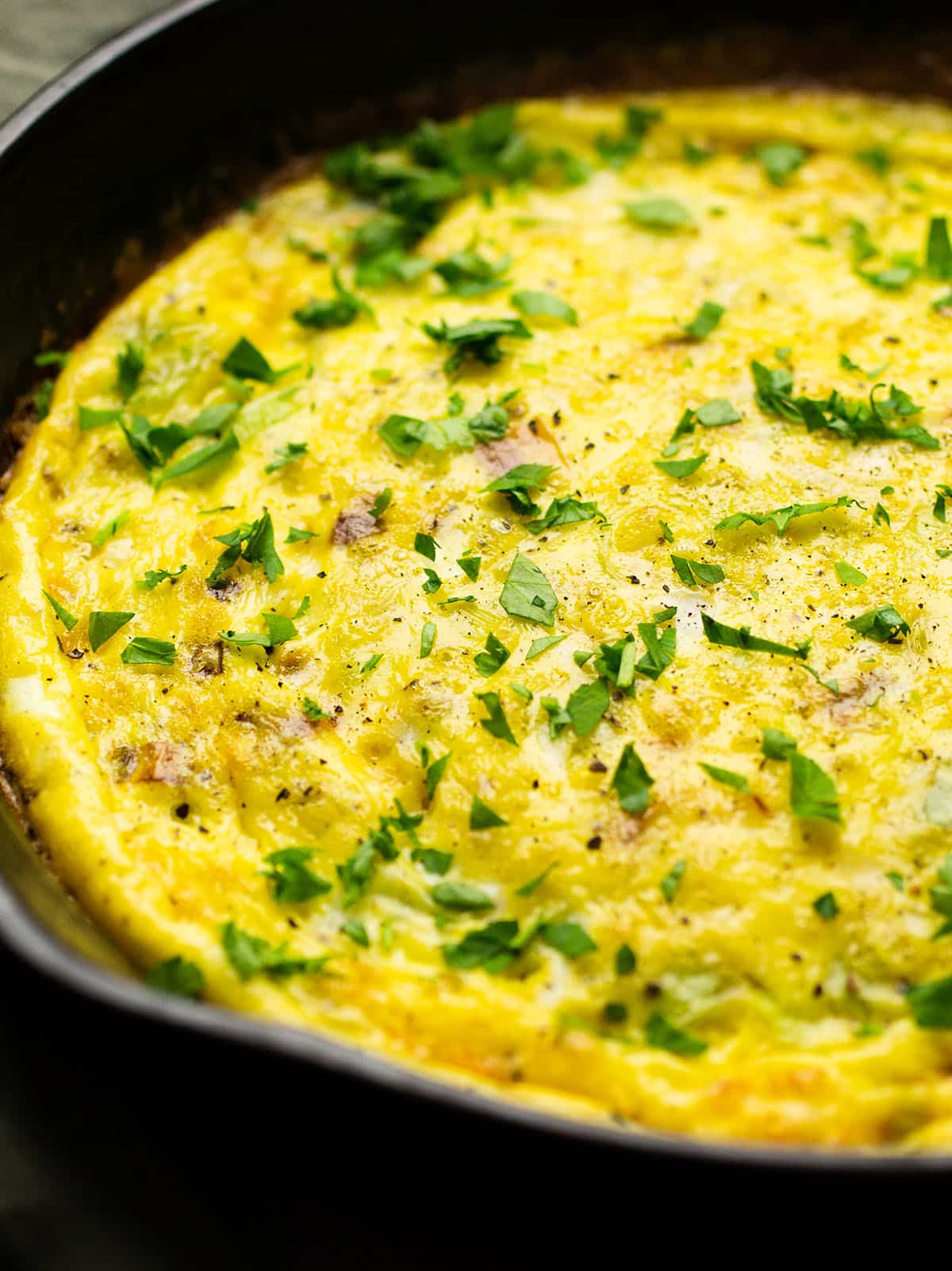 Frittata topped with chopped parsley.