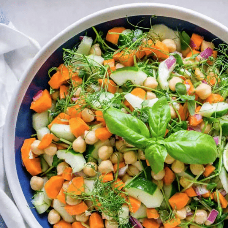 Chickpea salad with pea shoots in a blue bowl.