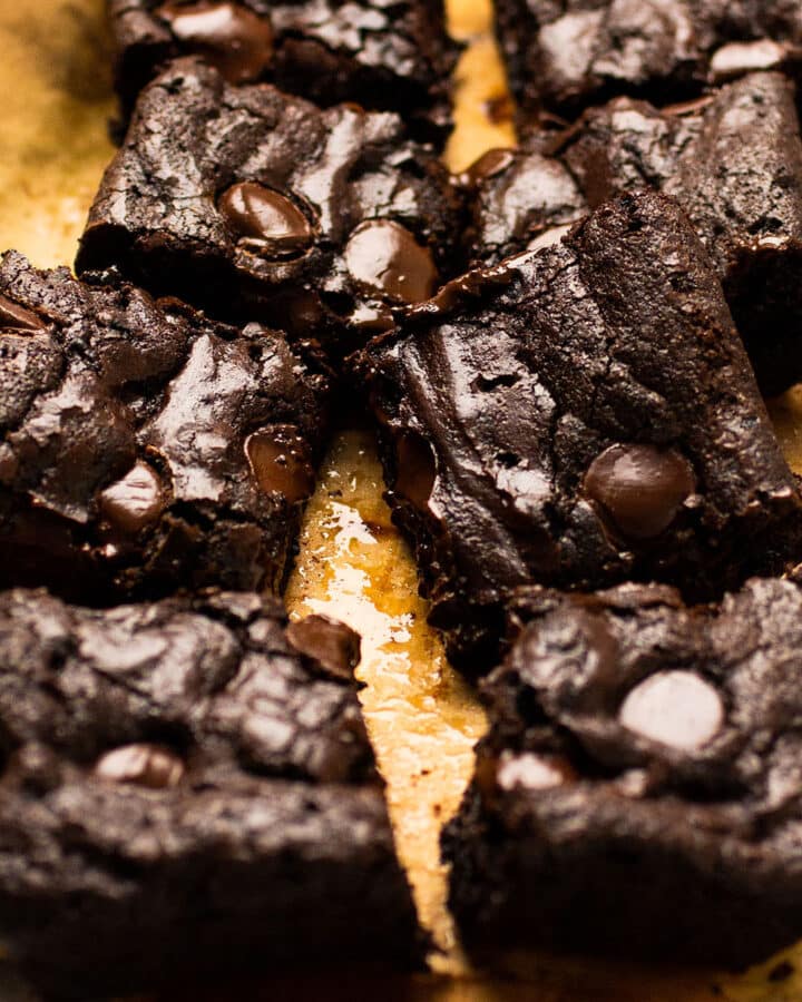 Sliced brownies on a piece of brown parchment paper.