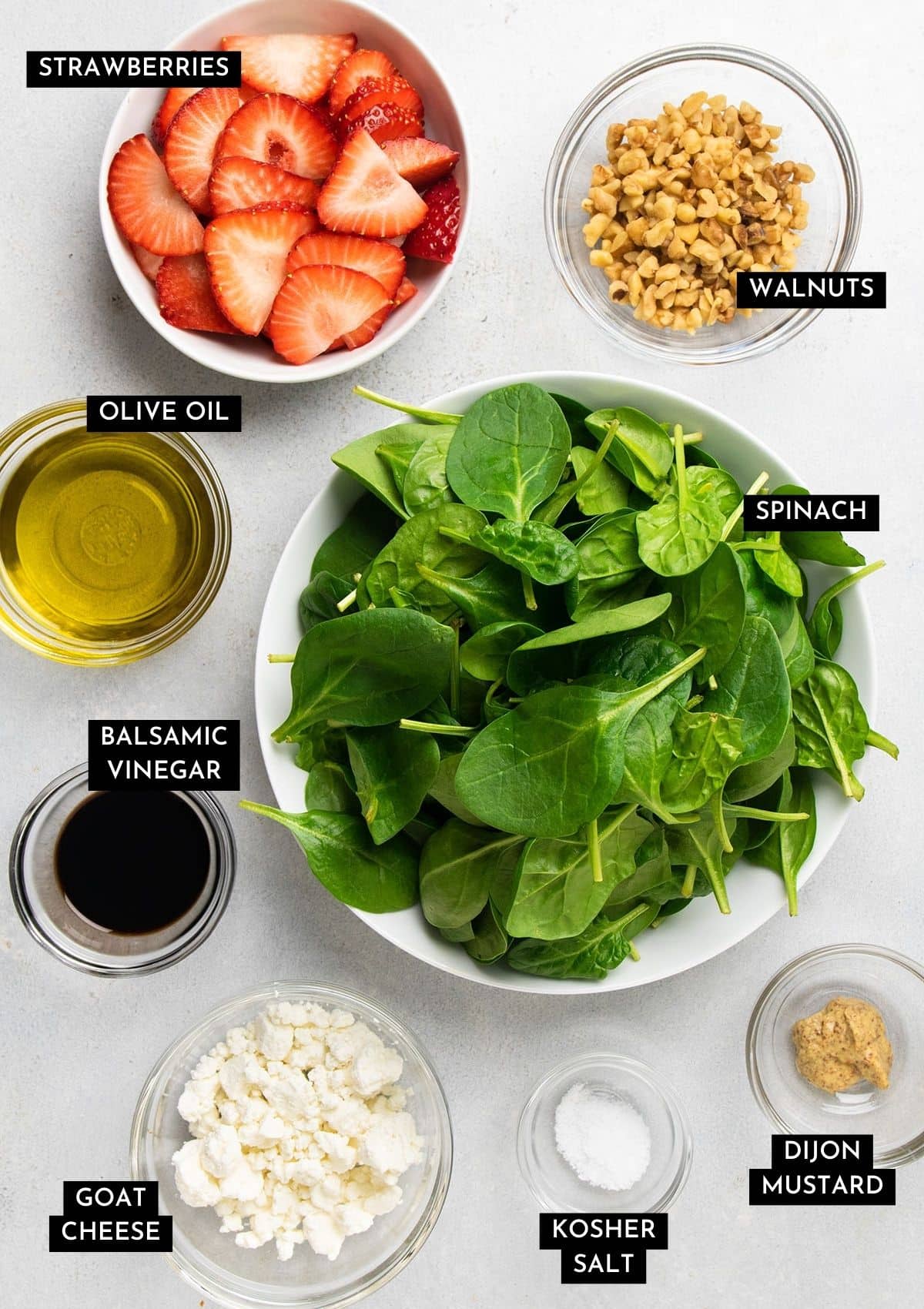 Spinach salad ingredients, organized into individual bowls.