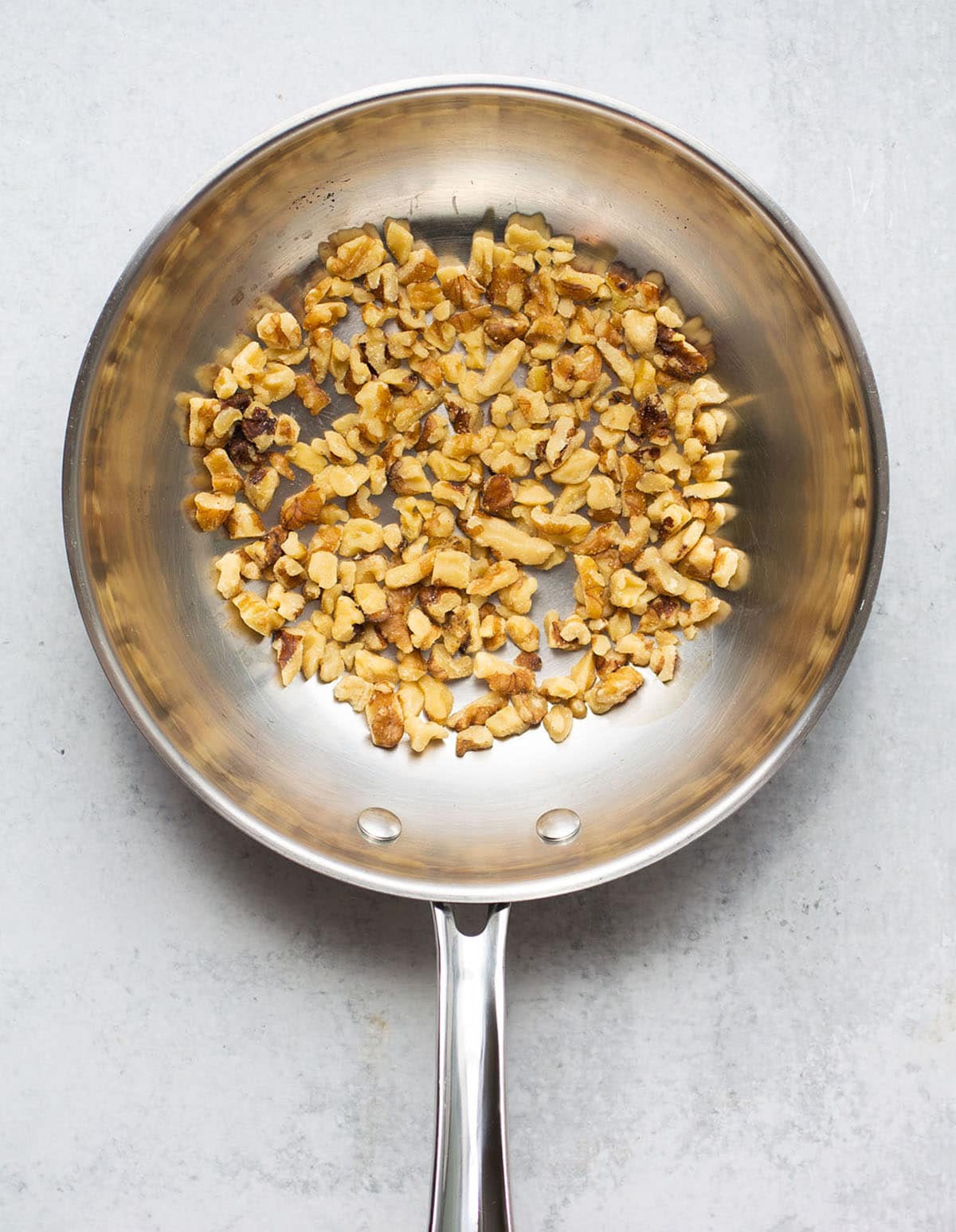 Toasting walnuts in a small skillet.