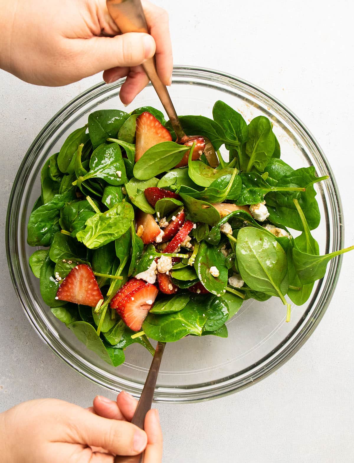 Tossing the salad together in a large bowl.
