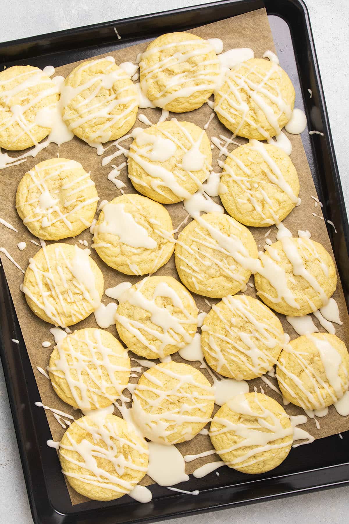 Iced lemon cookies on a sheet pan.